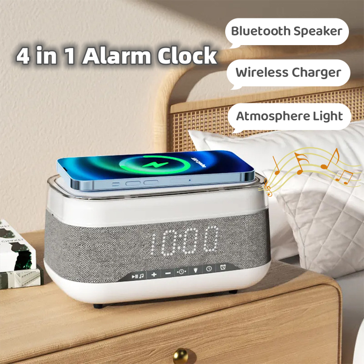 4-in-1 alarm clock with a wireless charger and speaker on a nightstand. The alarm clock is black and has a digital display. The wireless charger is white and is located on the top of the alarm clock. The speaker is black and is located on the side of the alarm clock. The nightstand is made of wood and has a lamp on it